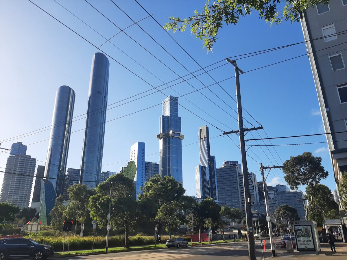Southbank high-rise apartment towers viewed from a tree-lined street, Melbourne