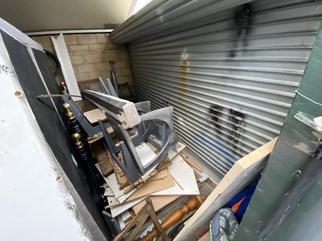 Shelving, a mattress and boards leaning by a garage roller door for collection