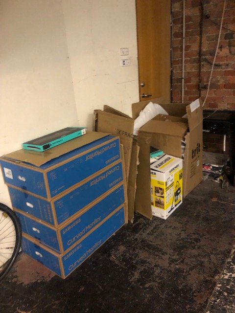 A chest of drawers and boxes of stored items cleared from a garage