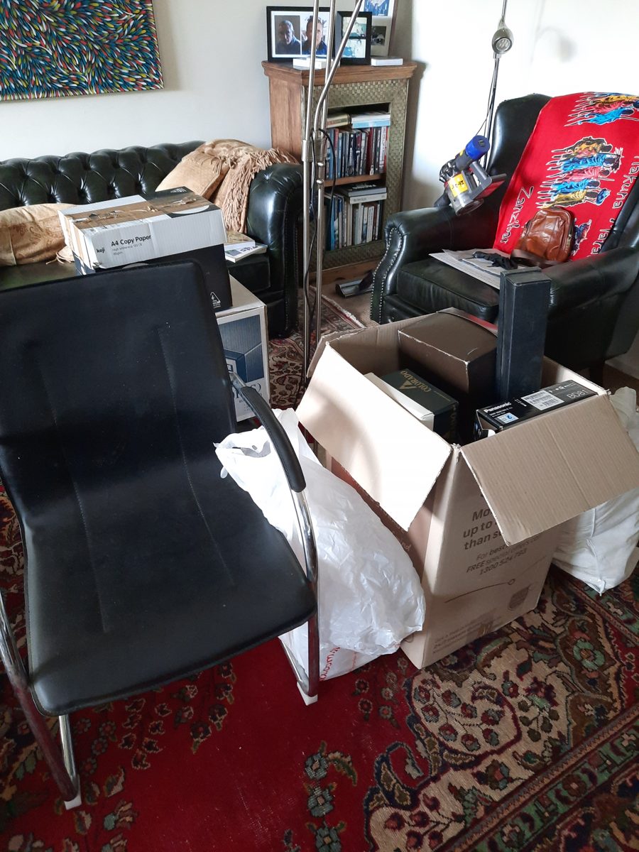 Office chair, boxes and household clutter cleared from a lounge room
