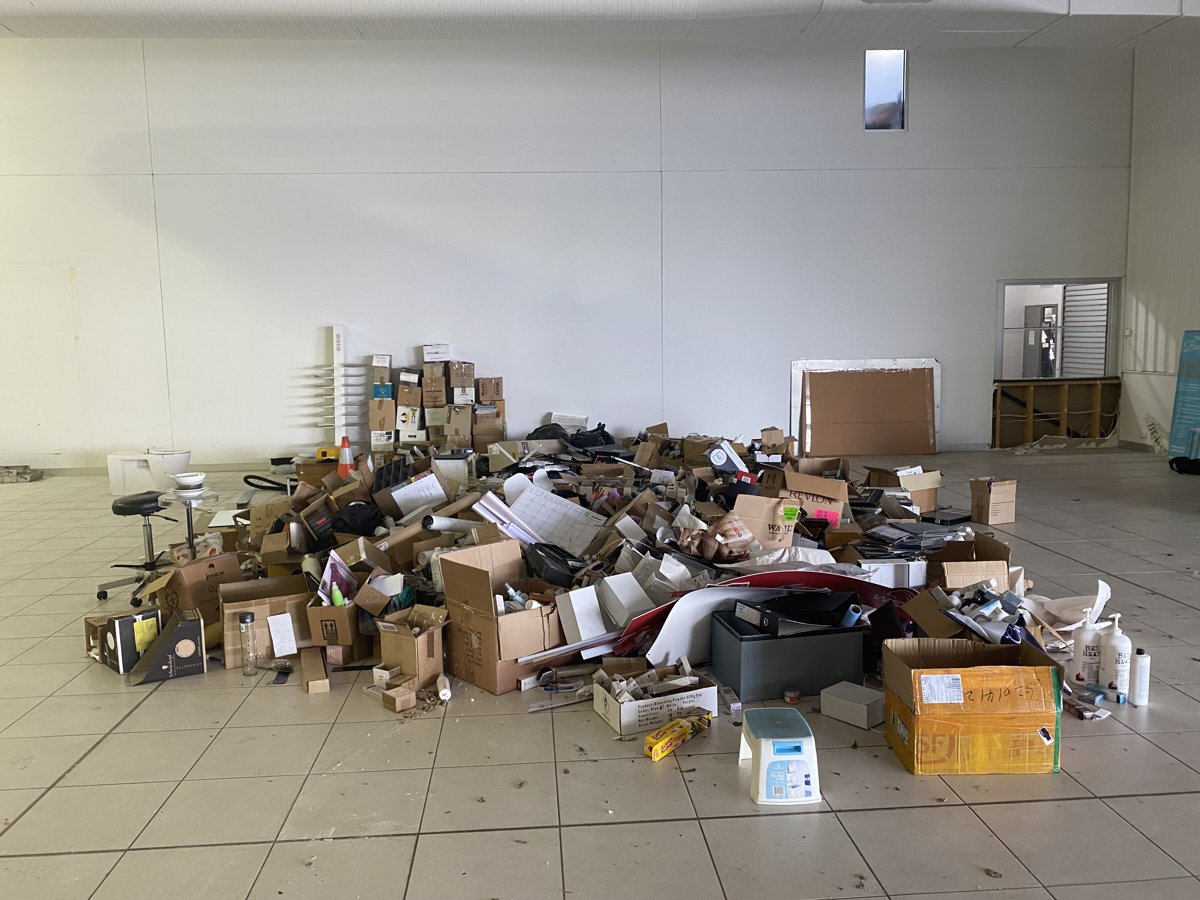 Large office floor piled with old furniture, boxes and equipment before an It's Done clearout